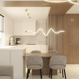 OLTOM WNĘTRZA ALEKSANDRA TOMALA - Nowoczesna aranżacja wnętrza: biała kuchnia z drewnianymi akcentami, designerska lampa nad stołem i marmurowa podłoga. Minimalistyczny styl i dbałość o detale.