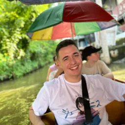 Uśmiechnięty mężczyzna w łodzi pod kolorowym parasolem, prawdopodobnie podczas eventu. Kielce.