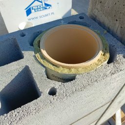 Betonowa Moc - Murowanie komina systemowego Schiedel z bloczków Solbet. Widoczna wełna izolacyjna. Praca w toku.