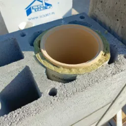 Murowanie komina systemowego Schiedel z bloczków Solbet. Widoczna wełna izolacyjna. Praca w toku.