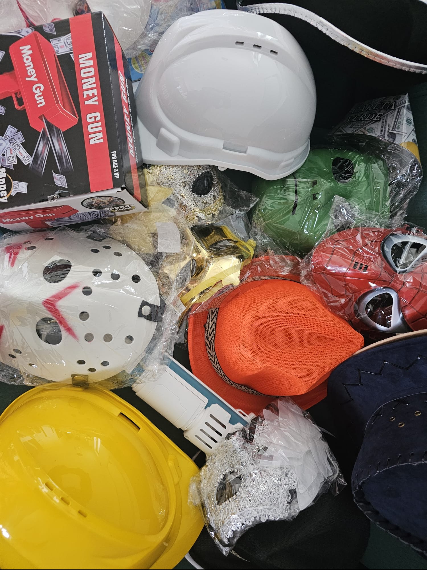 Różnorodne rekwizyty imprezowe: maski Jasona, Spider-Mana, kaski budowlane, pistolet na pieniądze. Akcesoria dla fotobudki, kostiumy na eventy tematyczne.