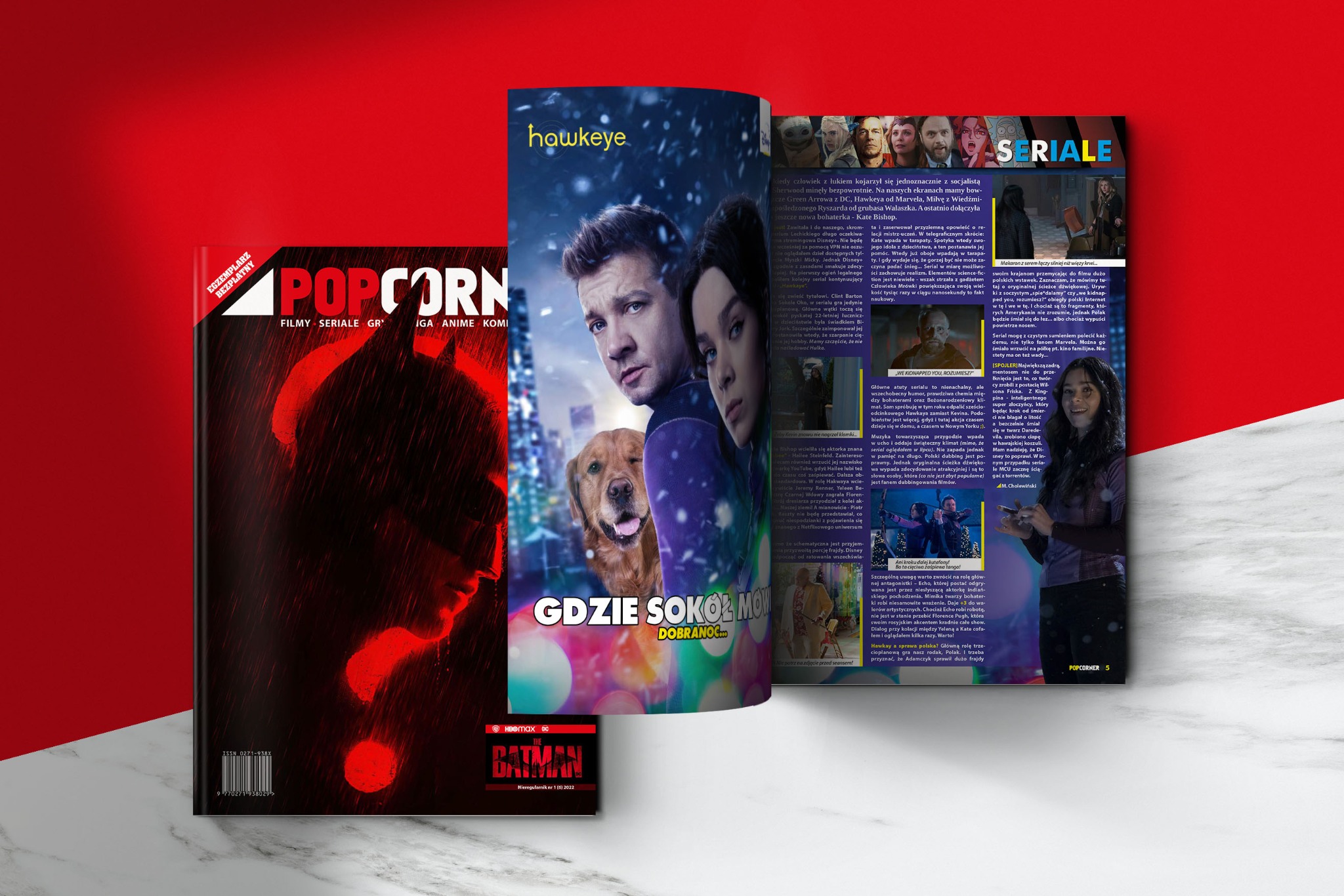 Okładka magazynu POPCORNER z motywem 'Hawkeye' i 'Batman'. Widoczne postacie z serialu, logo magazynu i tytuły artykułów. Czerwono-czarna kolorystyka.