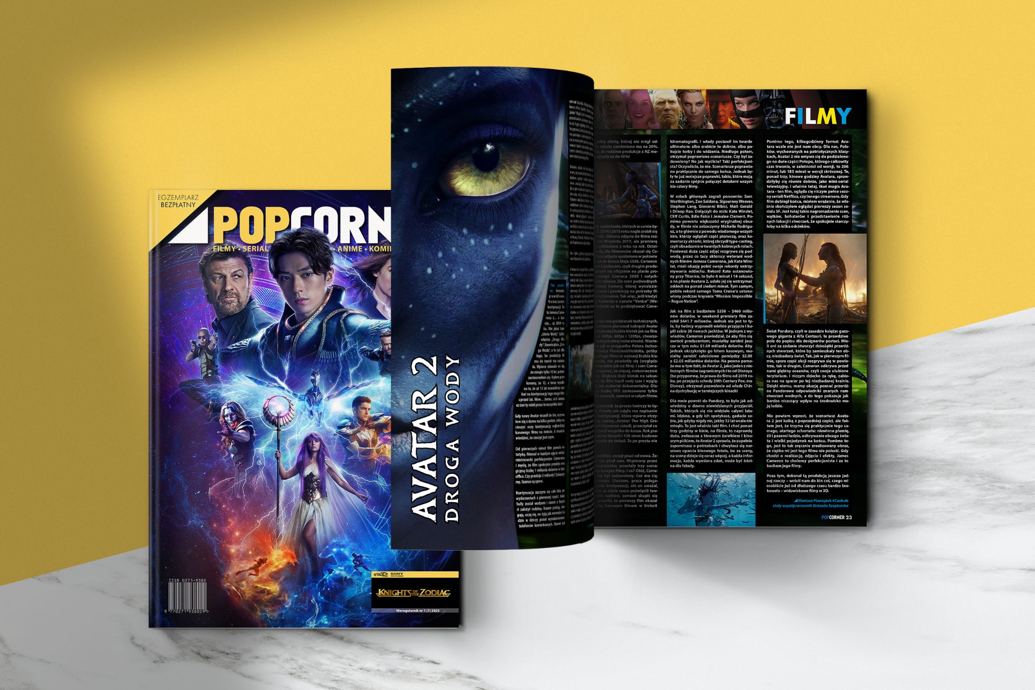 Rozłożony magazyn POPCORNER z okładką filmu Avatar 2 i artykułem o filmach, leżący na żółtym tle. Widoczne detale okładek i stron.