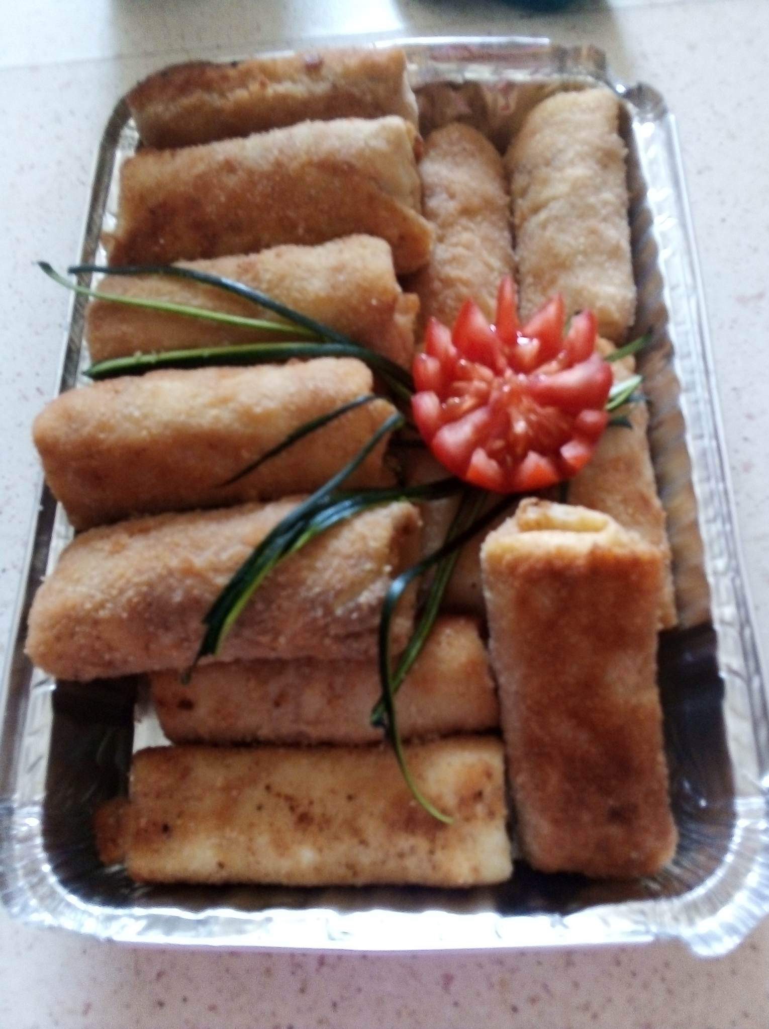 Krokiety w srebrnej tacce, udekorowane pomidorem i zielonymi gałązkami. Domowe danie gotowe do podania, widoczne z bliska.