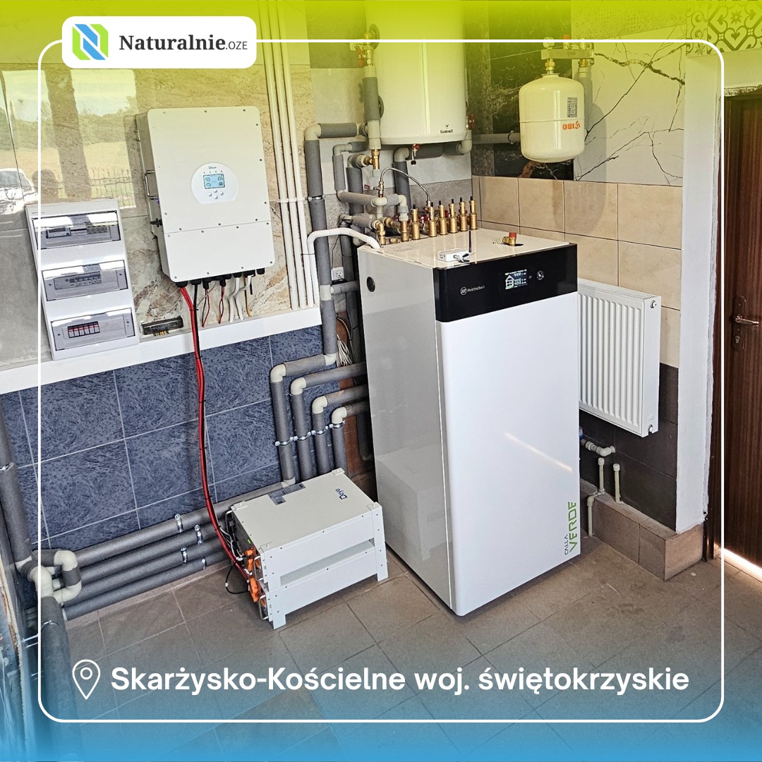 Kompletna instalacja grzewcza z pompą ciepła i fotowoltaiką w kotłowni, widoczne rury, zbiornik, inwerter. Dół kadru: akumulator. Lokalizacja: Skarżysko-Kościelne.