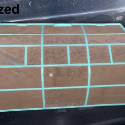 KAP-Instal - Brudny filtr klimatyzacji w plastikowej ramce, widoczny stan 'przed' czyszczeniem, zanieczyszczenia na siatce filtra.