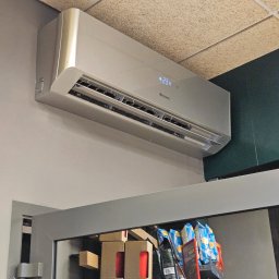 Nsinstal klimatyzacja wentylacja rekuperacja - Zamontowany klimatyzator Gree na ścianie w pomieszczeniu komercyjnym, widoczny wyświetlacz temperatury 23 stopnie Celsjusza. W tle regał z produktami.