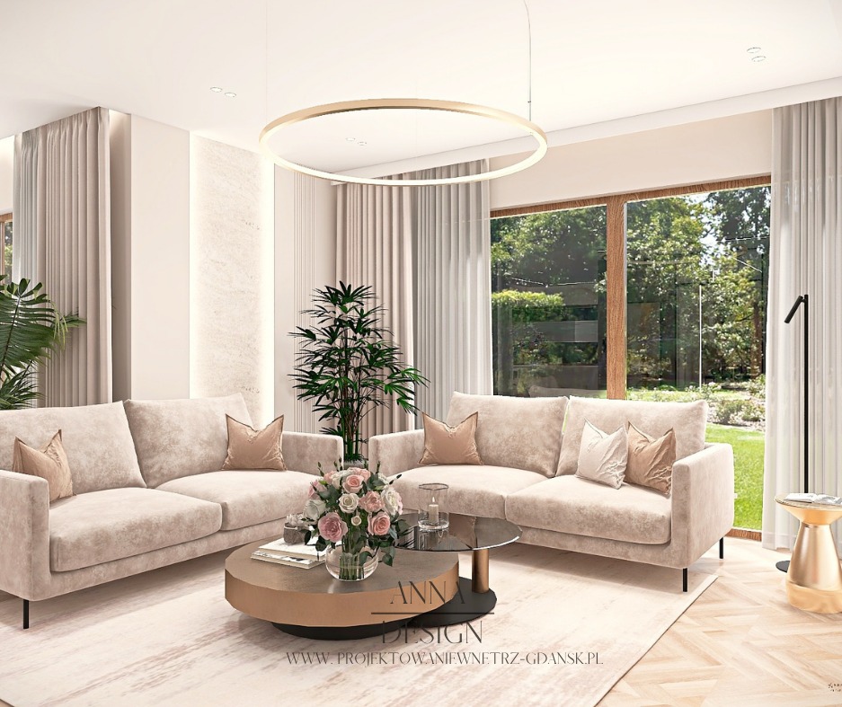 Jasny salon z dwoma beżowymi sofami, okrągłym stolikiem kawowym i dużym oknem z widokiem na zieleń. Minimalistyczny design z roślinami doniczkowymi i okrągłą lampą.