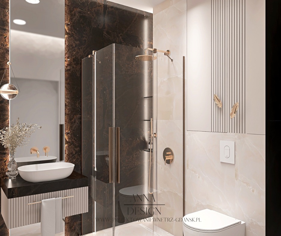 Elegancka łazienka z kabiną prysznicową typu walk-in, umywalką nablatową i lustrem. Marmurowe wykończenie ścian i złote akcenty dodają luksusowego charakteru.