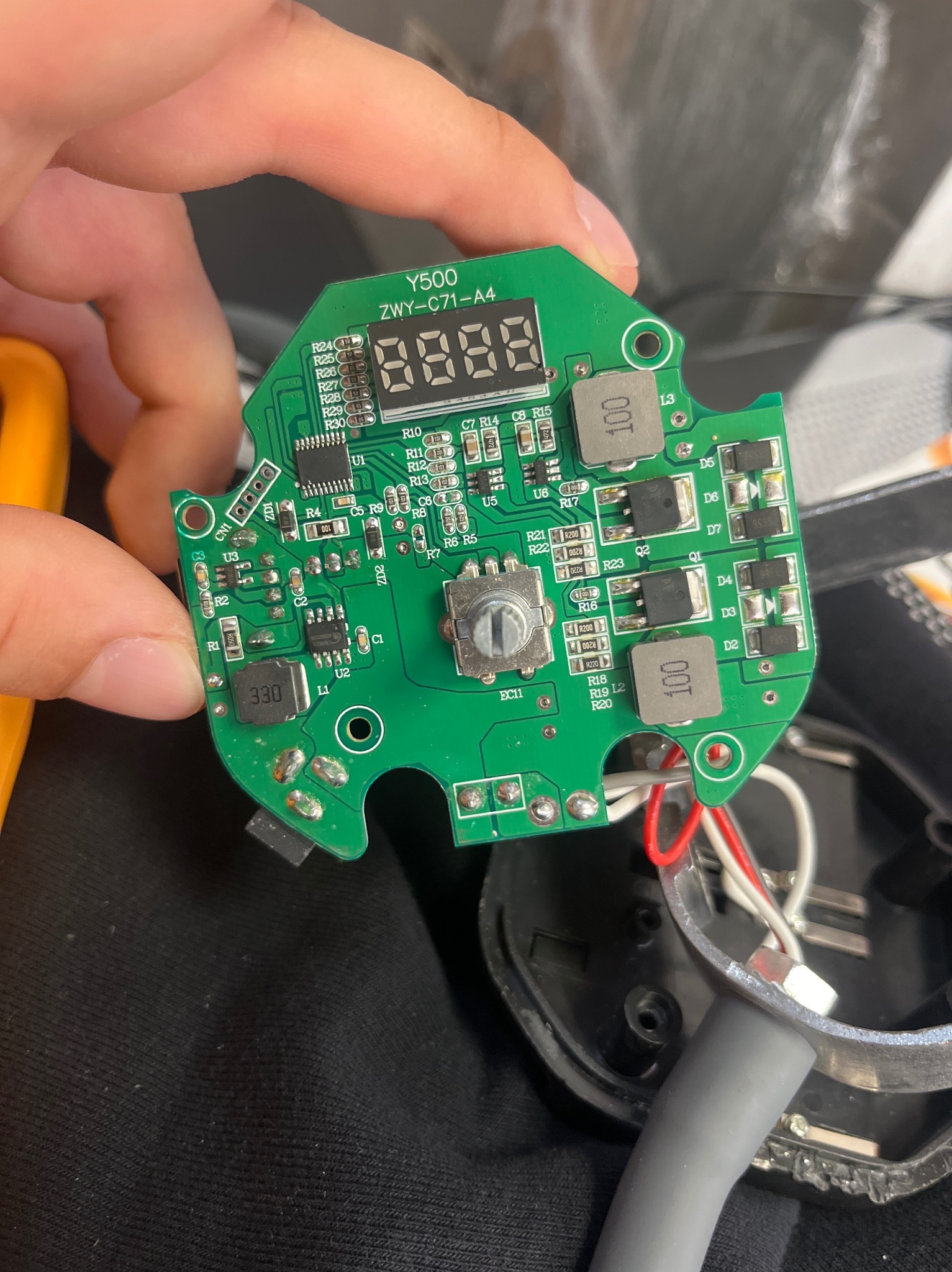 Zielona płytka drukowana Y500 ZWY-C71-A4 z elementami elektronicznymi, trzymana w dłoni, widoczne układy scalone, rezystory i kondensatory. Kabel zasilający w tle.