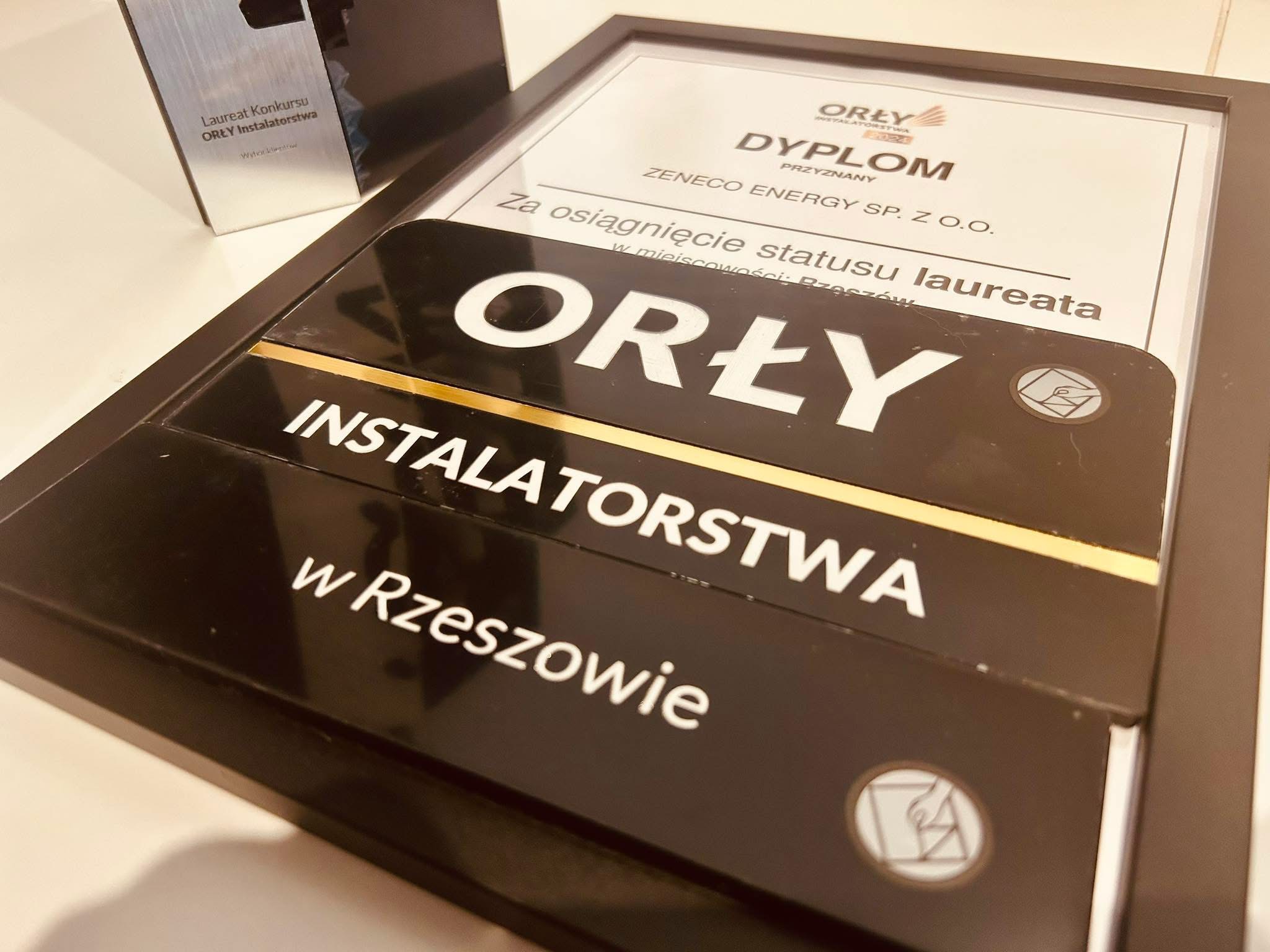 Dyplom 'Orły Instalatorstwa' dla Zeneco Energy Sp. z o.o. za osiągnięcie statusu laureata w Rzeszowie, prezentowany obok statuetki konkursowej.