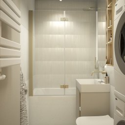 Space Creations - Studio projektowe Katarzyna Tajduś-Bzymek - Beżowa łazienka z wanną za szklaną ścianką, umywalką na szafce i toaletą wiszącą. Obok pralka i suszarka w zabudowie. Minimalistyczny design z akcentami złota.