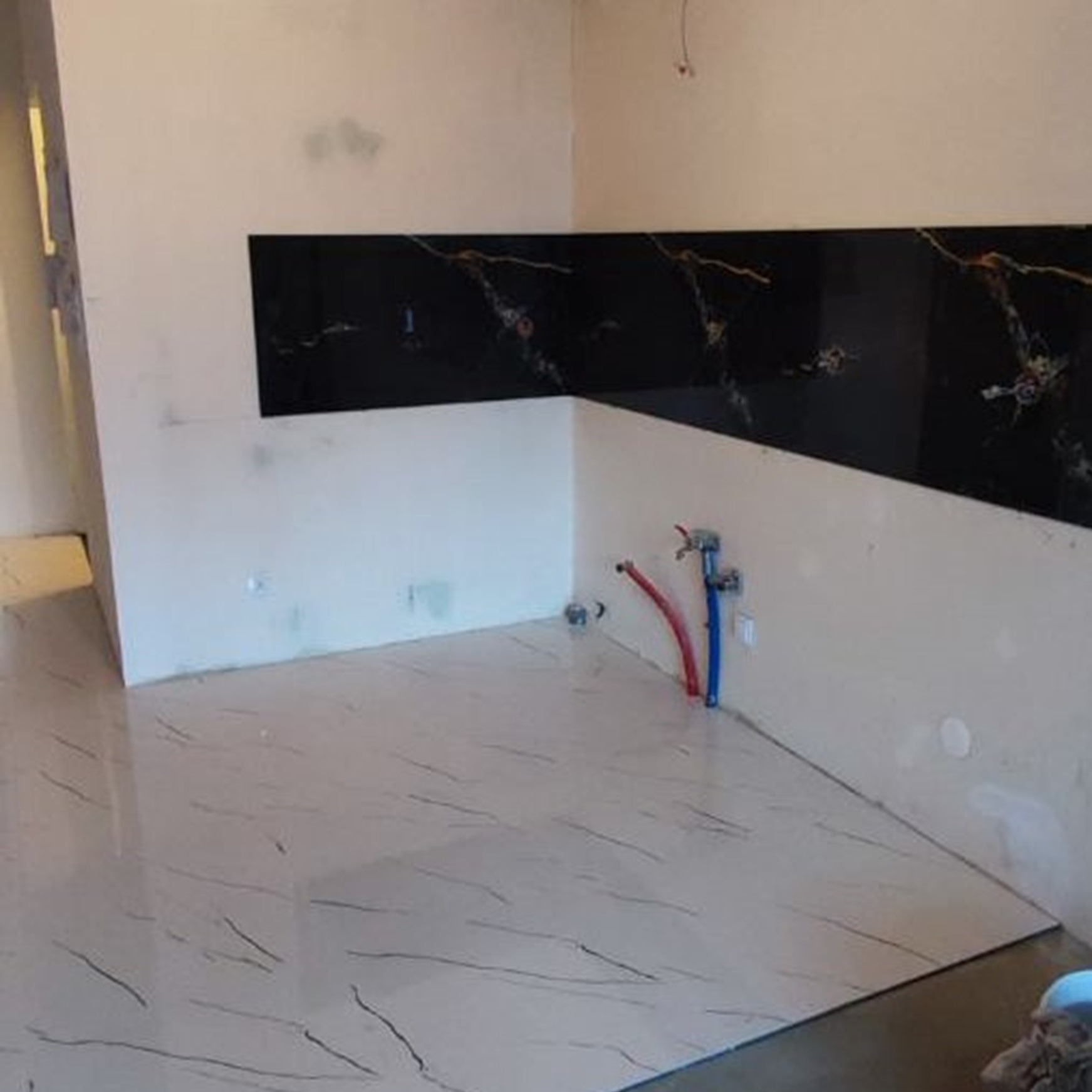 Realizacja układania płytki w części aneksu kuchennego na posadzce i ścianie.