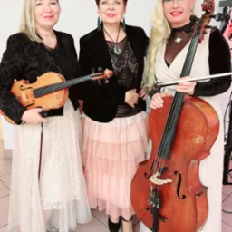 Elegancki damski zespół smyczkowy w stylizowanych sukniach. Dwie skrzypaczki i wiolonczelistka prezentują instrumenty. Scena w jasnych barwach.