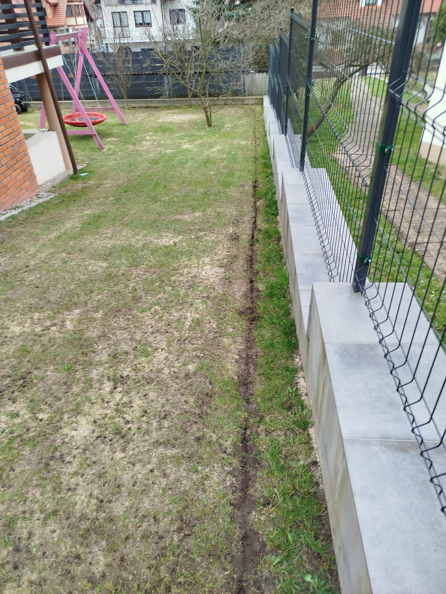 Zakopywanie przewodu ograniczającego dla robota koszacego.