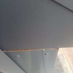 ASSAMAH-VH Vasyl Habiak - Szczegółowe ujęcie fragmentu dachu z widoczną izolacją i elementami mocującymi, ukazujące precyzję wykonania i dbałość o detale w pracach dekarskich.