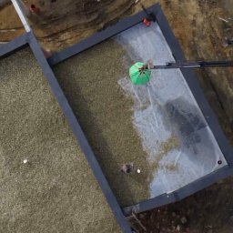 cousinroof - Widok z góry na dach z zielonymi elementami, prawdopodobnie podczas prac związanych z jego budową lub renowacją. Na dachu widoczni pracownicy i sprzęt budowlany.