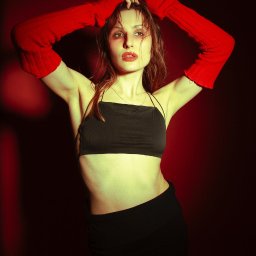 Pinky Foto - Amelia Jaworska - Portret kobiety w czerwonych rękawiczkach na tle ciemnego studia w Mielcu. Modelka ma mokre włosy i pozuje z rękami uniesionymi nad głową. Czerwone oświetlenie.