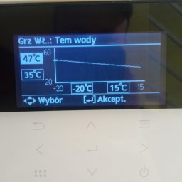 INERGY TECH Michał Pyła - Ekran sterownika temperatury wody grzewczej z wykresem i wartościami 47°C i 35°C. Widoczne przyciski wyboru i akceptacji. Biała obudowa sterownika.