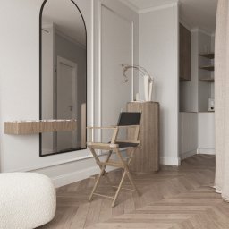 Aleksandra Ciesielska Architektura - Neutralne wnętrze z parkietem w jodełkę, czarnym lustrem w łukowej ramie i drewnianym krzesłem reżyserskim. Minimalistyczny design i spokojna kolorystyka.