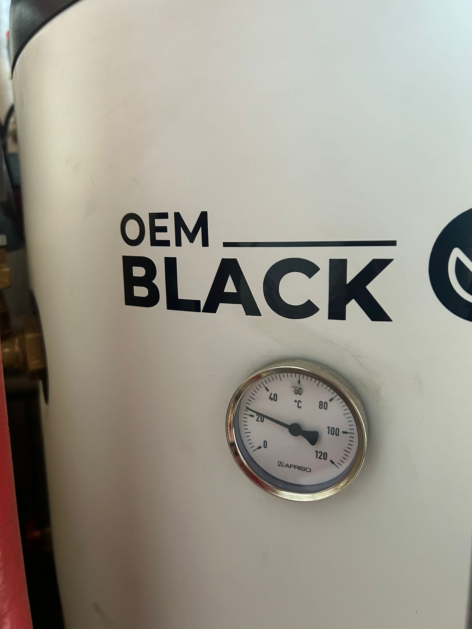 Biały zbiornik OEM BLACK z termometrem AFRISO, instalacja grzewcza w Ostrowcu Świętokrzyskim. Widoczny fragment rury i zaworu.