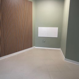 Czysty Dom - Wnętrze po remoncie: jasne płytki podłogowe, ściany w odcieniach zieleni, dekoracyjna drewniana listwa na ścianie. Minimalistyczny design, czystość i porządek.