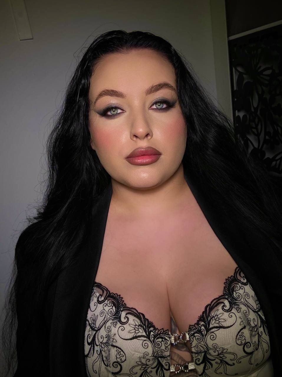 Portret kobiety z ciemnym, wieczorowym makijażem oczu, podkreślonymi kośćmi policzkowymi i ustami w odcieniach nude. Uczesanie z długich, czarnych włosów.