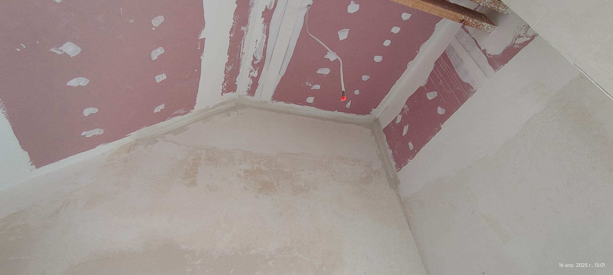 Poddasze po montażu płyt gipsowo-kartonowych, widoczne łączenia płyt i szpachlowanie. Fragment instalacji elektrycznej na suficie. Ściany przygotowane do malowania.