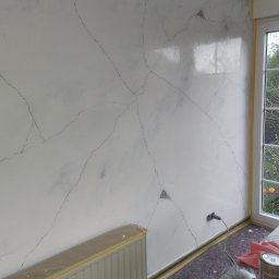 Andrzej Smykla - Ściana w pokoju po dekoracyjnym malowaniu imitującym marmurkowe żyłki. Grzejnik i podłoga zabezpieczone folią i taśmą. Widoczne narzędzia malarskie.