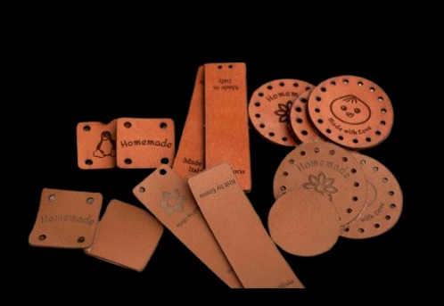 Brązowe, skórzane etykiety z wygrawerowanymi wzorami i napisami, wykonane w Woli Mysłowskiej. Precyzyjne cięcie laserowe detali.