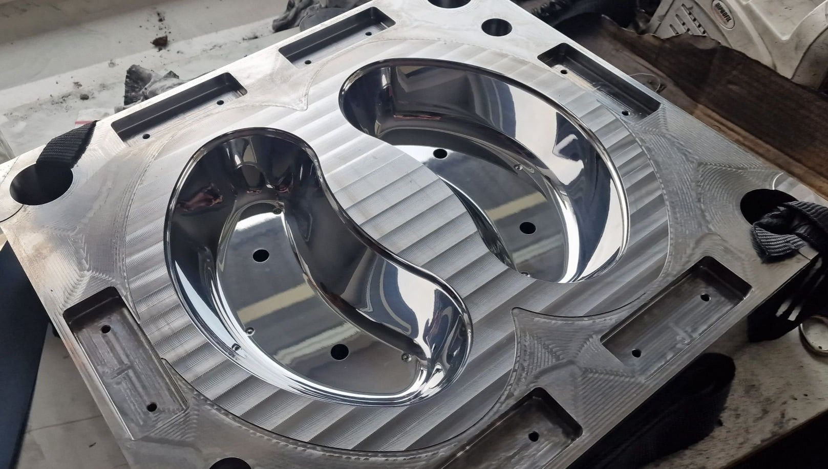 Precyzyjnie obrobiona, błyszcząca forma wtryskowa z dwoma gniazdami o nieregularnym kształcie, widoczne ślady frezowania i otwory montażowe.