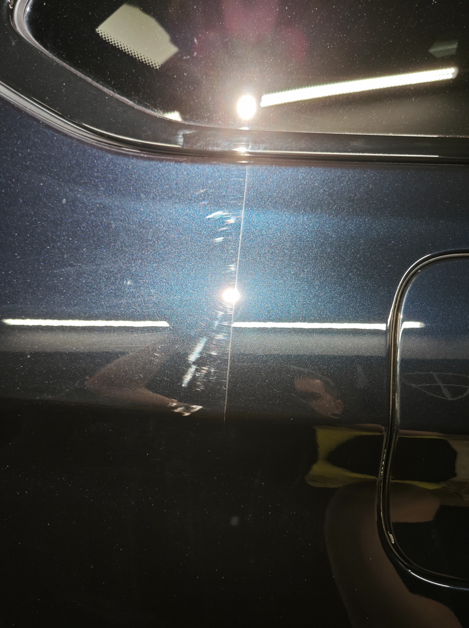 Błyszcząca, metaliczna karoseria samochodu po polerowaniu, z widocznymi refleksami światła, ukazująca detale lakieru i brak zarysowań.