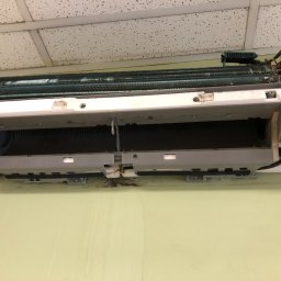 AS - CLIMATECH Arkadiusz Sosna - Zdemontowany, brudny klimatyzator ścienny w trakcie serwisu. Widoczne zanieczyszczenia na elementach wewnętrznych i obudowie. Otwarta konstrukcja ukazuje stan przed czyszczeniem.