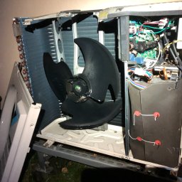 AS - CLIMATECH Arkadiusz Sosna - Otwarta obudowa klimatyzatora z widocznym wentylatorem i elektroniką. Panel boczny zdjęty, widoczne elementy wewnętrzne urządzenia. Przegląd techniczny w trakcie.