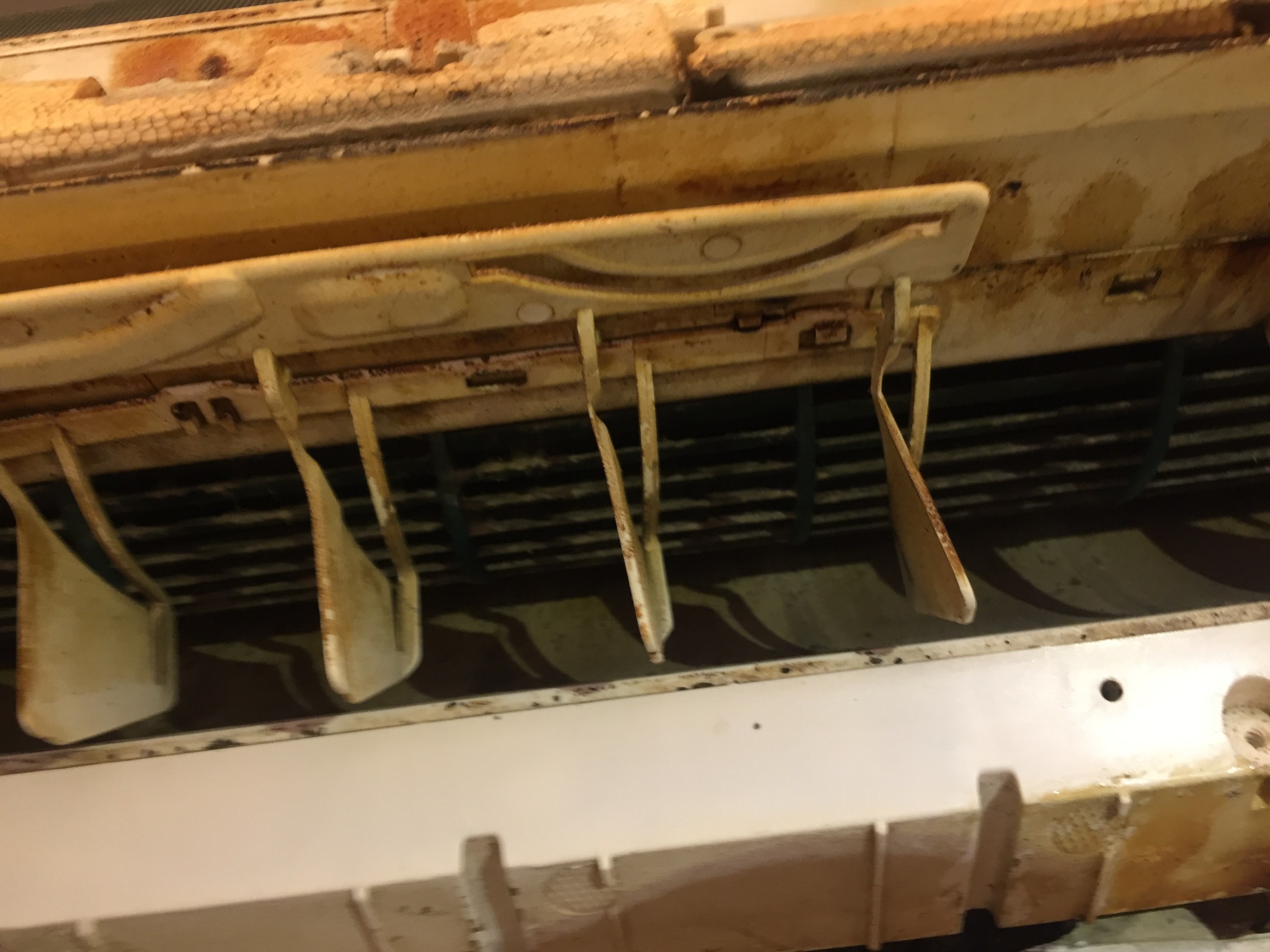 Zanieczyszczone wnętrze klimatyzatora z widocznymi filtrami i lamelami, wymagające pilnego czyszczenia i serwisu. Widoczne ślady korozji.