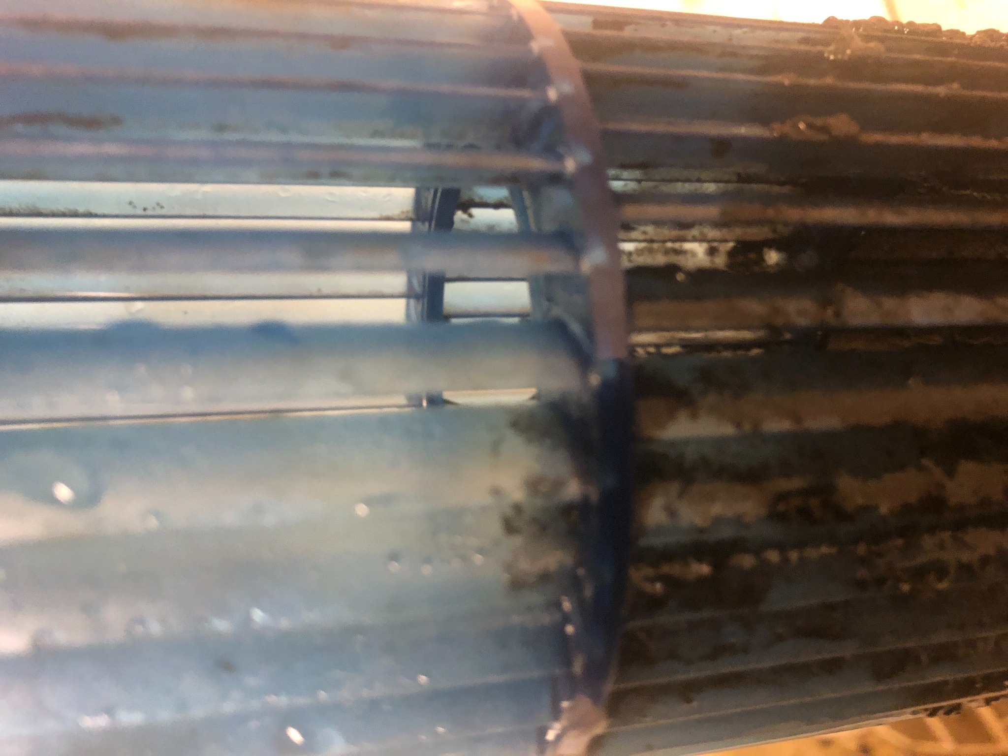 Zanieczyszczone lamele wentylatora osiowego, widoczne osady i zabrudzenia. Element instalacji wentylacyjnej wymagający czyszczenia lub serwisu.