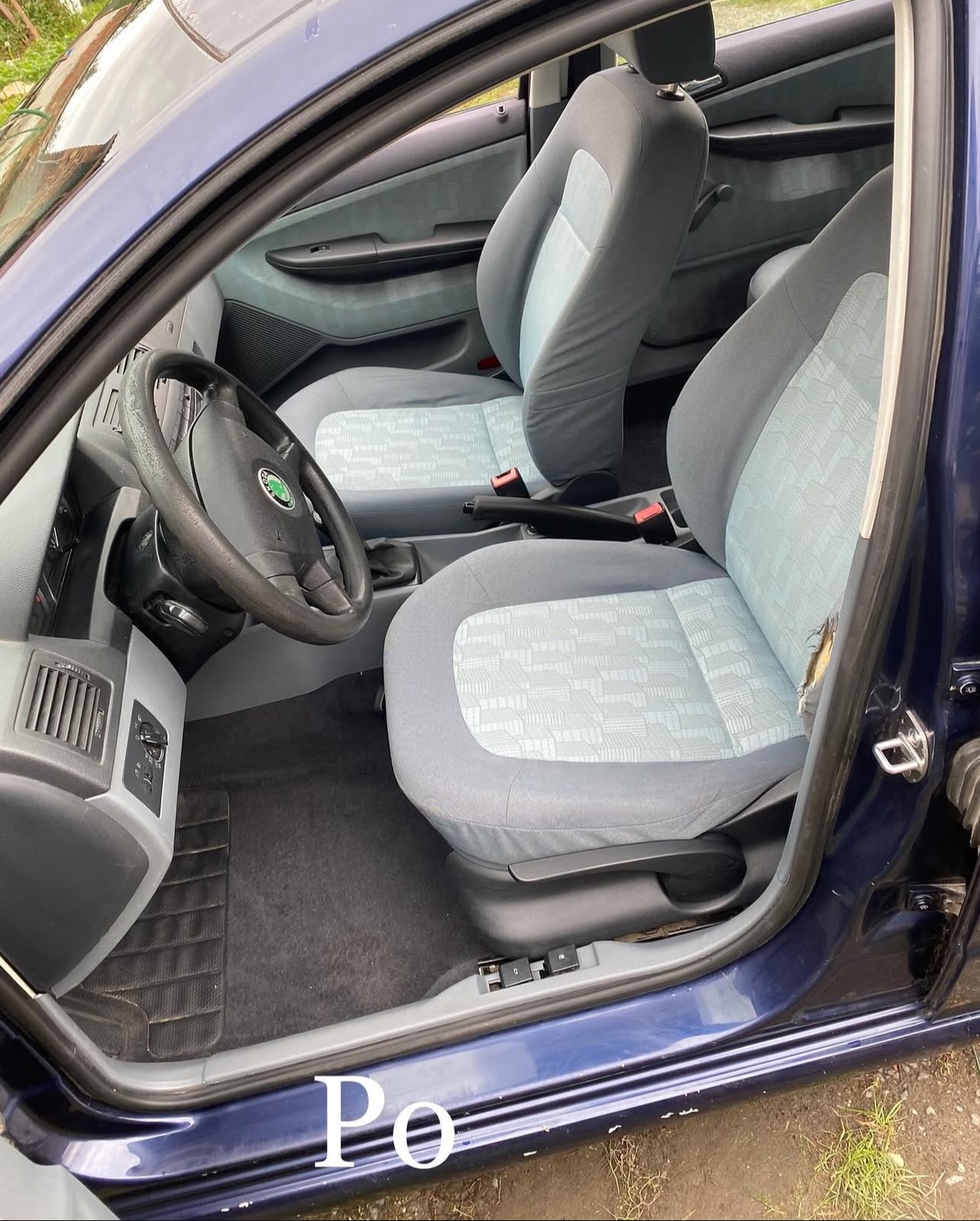 Wnętrze auta po czyszczeniu tapicerki. Jasne fotele z delikatnym wzorem, widoczna kierownica i deska rozdzielcza. Czyste dywaniki i odświeżony wygląd wnętrza.