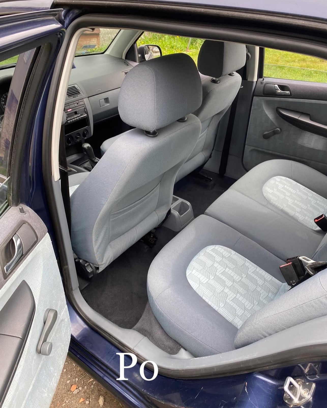 Wnętrze samochodu po czyszczeniu: jasnoszare fotele z subtelnym wzorem, otwarte drzwi ukazują czystą tapicerkę, widoczne detale wnętrza.