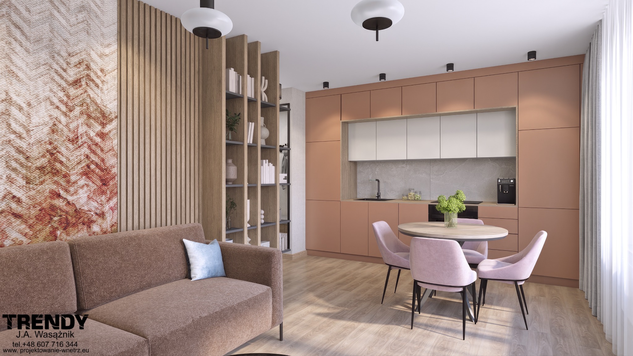 Stylowe wnętrze z otwartą kuchnią i salonem. Miedziane szafki kuchenne, okrągły stół z różowymi krzesłami. W salonie brązowa sofa z dekoracyjną ścianą z lameli i tapetą.