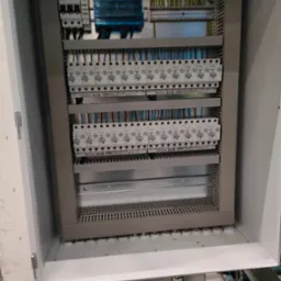 Otwarta szafa elektryczna z zainstalowanymi bezpiecznikami Eaton i okablowaniem, widok z góry.