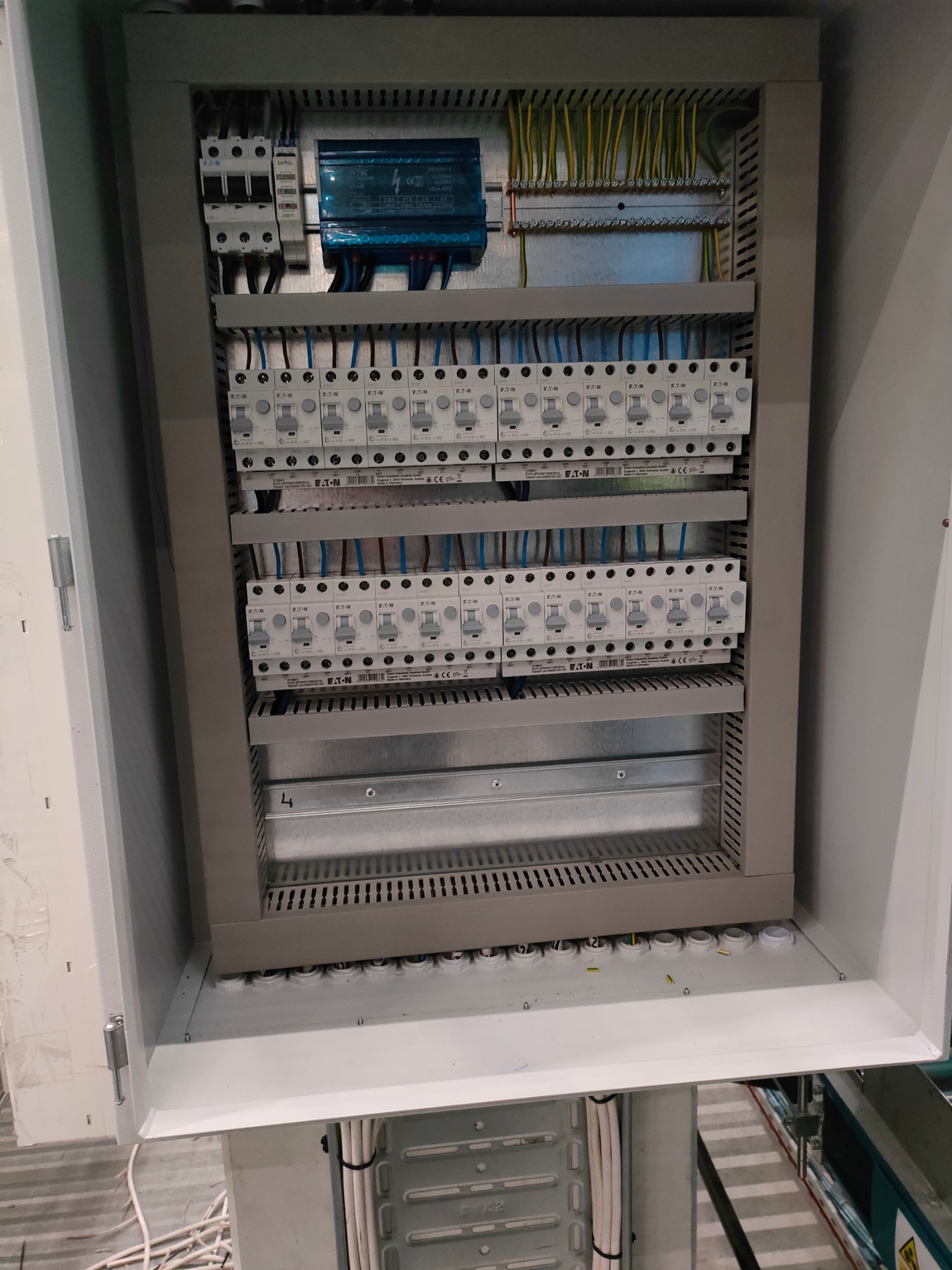 Otwarta szafa elektryczna z zainstalowanymi bezpiecznikami Eaton i okablowaniem, widok z góry.