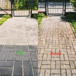 Efekt 'przed i po' mycia kostki brukowej w Puszczykowie. Po lewej czysta, szara kostka, po prawej zabrudzona, porośnięta mchem. Widoczna brama w tle.