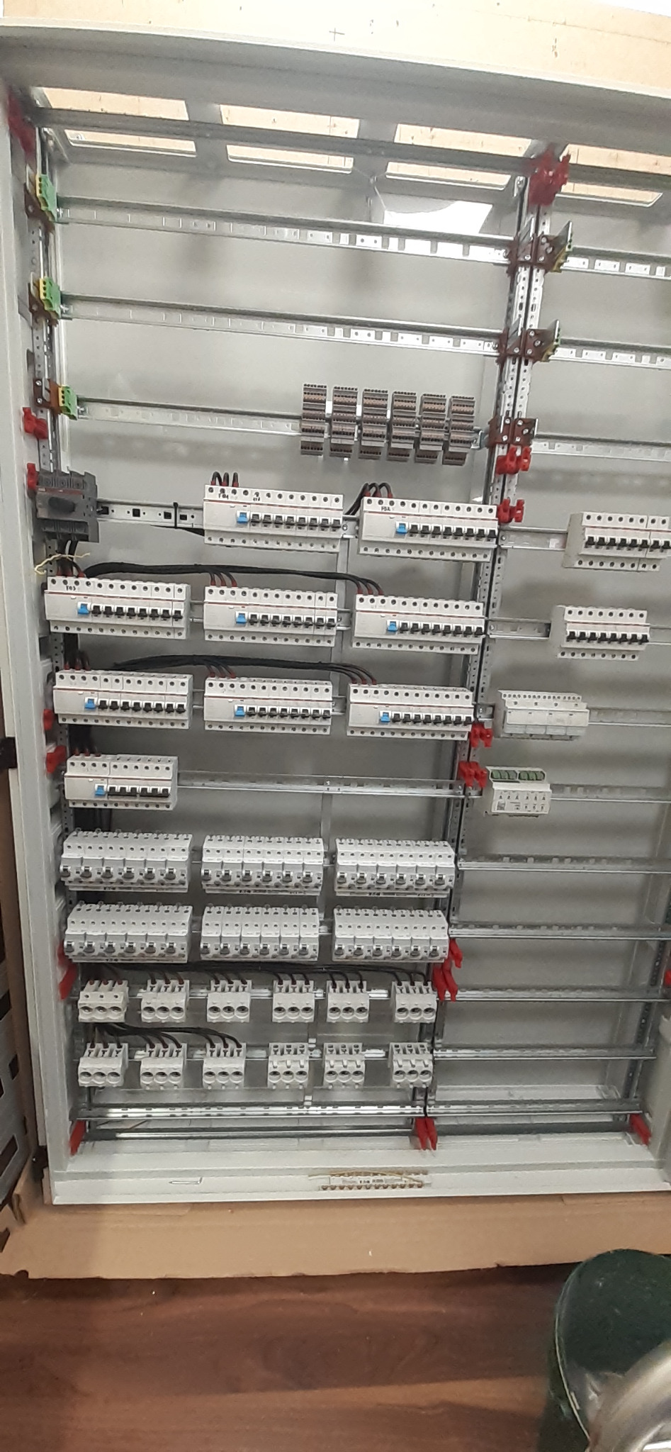 Rozdzielnica elektryczna w trakcie montażu, widoczne zabezpieczenia, listwy zaciskowe i przewody. Realizacja instalacji w skrzynce rozdzielczej.