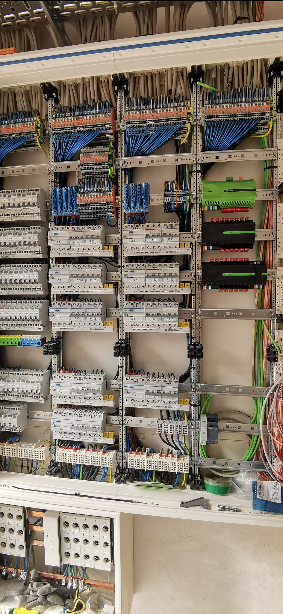 Rozbudowana szafa elektryczna z precyzyjnie ułożonymi przewodami, zabezpieczeniami i modułami sterującymi, widok z bliska na detale instalacji.