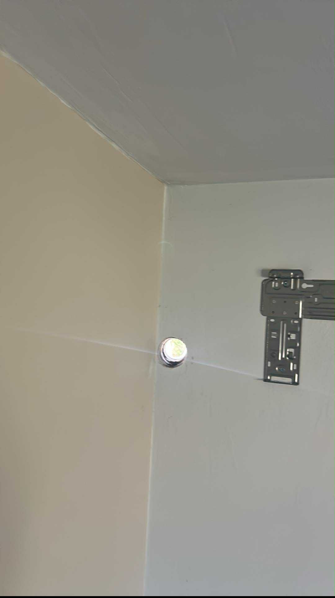 Ściana z otworem na instalację klimatyzacji i zamocowanym uchwytem montażowym. Widoczne przewody. Przygotowanie do montażu klimatyzatora.