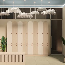 Bjorn Studio Karolina Strzelczyk - Pastelowe wnętrze z szafkami w stylu Montessori, lampami w kształcie chmur i roślinami doniczkowymi. Jasne drewno i błękitne akcenty tworzą spokojną atmosferę.
