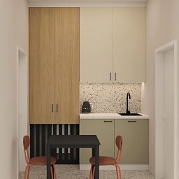 Bjorn Studio Karolina Strzelczyk - Kompaktowa kuchnia w neutralnych barwach: drewniane i beżowe szafki, czarny stół z krzesłami na tle mozaikowej ściany i podłogi. Minimalistyczny design, czajnik Smeg.