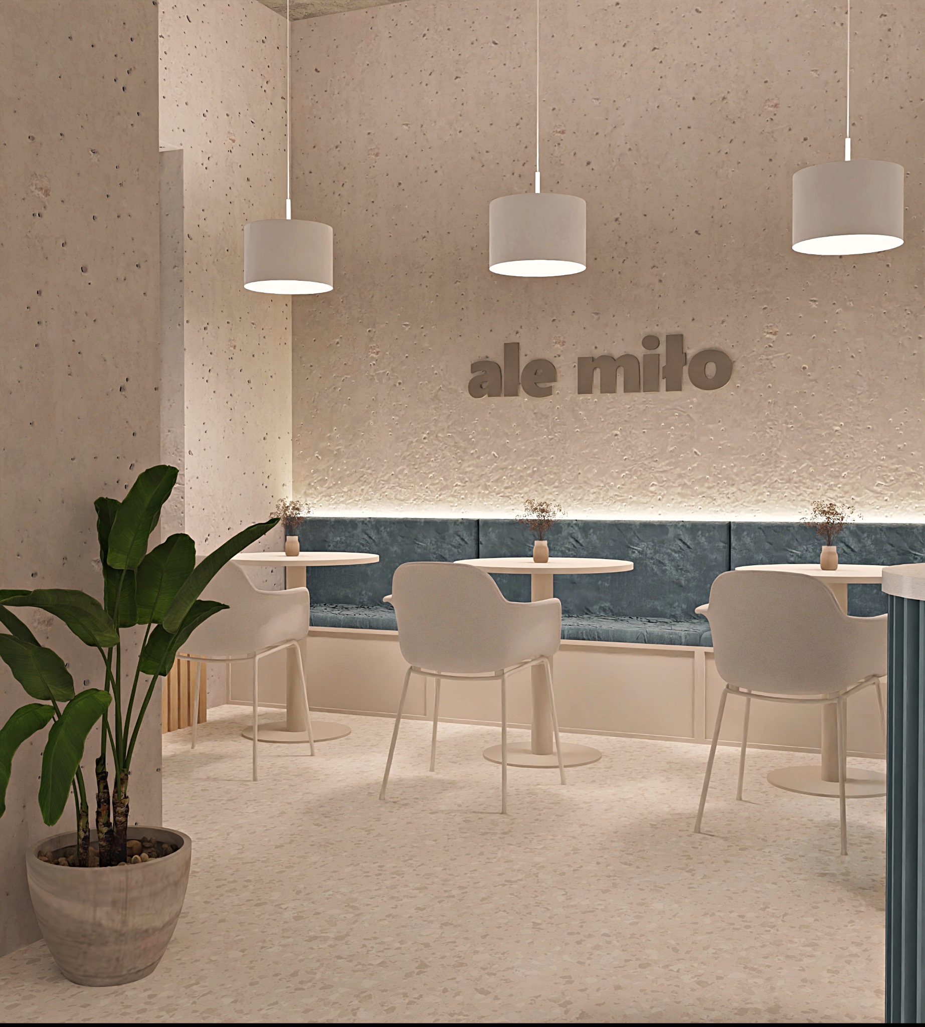 Wnętrze kawiarni w stonowanej kolorystyce z rośliną w donicy. Na ścianie napis 'ale miło', oświetlenie punktowe, jasne meble i podłoga z terazzo.