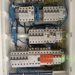 SŁAWOMIR RUDNIK BSM-SERWIS - Rozdzielnia elektryczna w białej obudowie, widoczne zabezpieczenia EATON i ETI, przewody w różnych kolorach, listwy zaciskowe. Instalacja po montażu, gotowa do użytku.