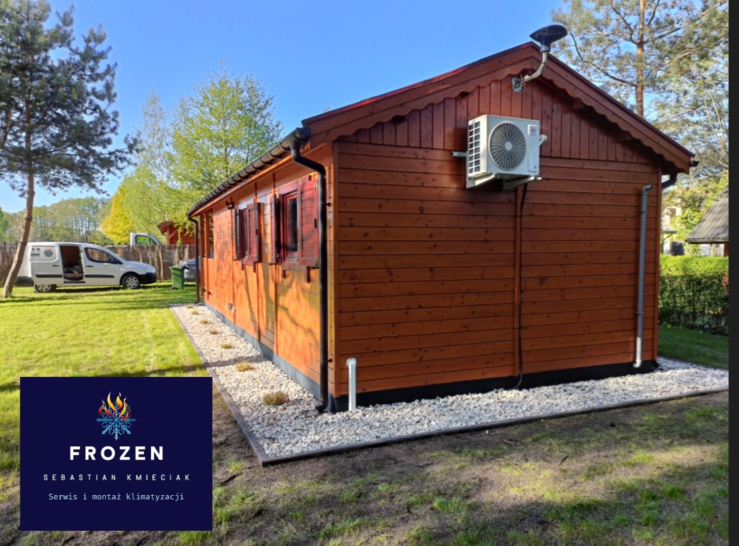 Brązowy domek z zamontowaną klimatyzacją na zewnątrz. Widoczny biały agregat i instalacja. Na trawniku stoi biały samochód dostawczy.
